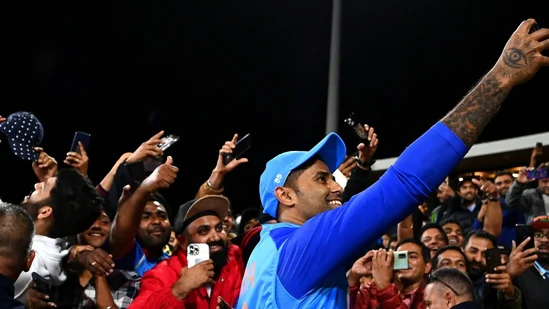 Suryakumar Yadav surrounded by enthusiastic fans seeking selfies while fielding during Buchi Babu tournament